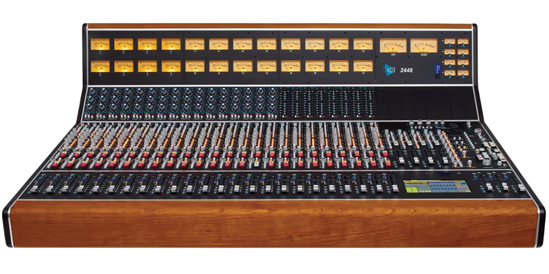 API 2448, a professional analog recording console with a warm wooden frame, numerous faders, knobs, and clear VU meters.